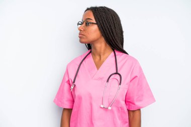 black pretty woman on profile view thinking, imagining or daydreaming. nurse concept