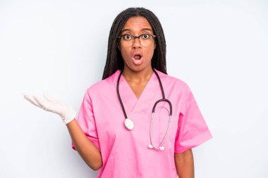 black pretty woman looking surprised and shocked, with jaw dropped holding an object. nurse concept