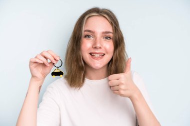 caucasian pretty woman feeling proud,smiling positively with thumbs up. new car concept