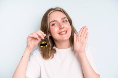 caucasian pretty woman smiling happily, waving hand, welcoming and greeting you. new car concept