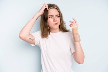 caucasian pretty woman feeling puzzled and confused, scratching head. broken hand concept