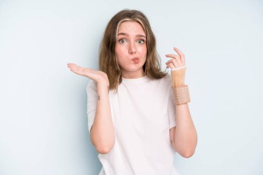 caucasian pretty woman feeling puzzled and confused and doubting. broken hand concept