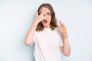 caucasian pretty woman looking shocked, scared or terrified, covering face with hand. broken hand concept