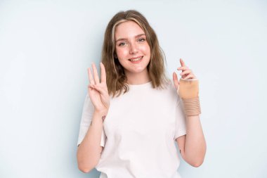 caucasian pretty woman smiling and looking friendly, showing number three. broken hand concept