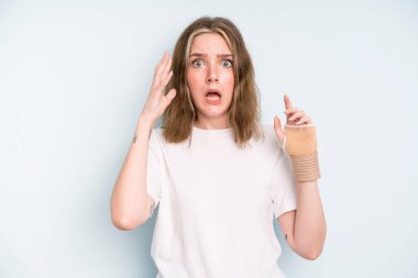 caucasian pretty woman screaming with hands up in the air. broken hand concept