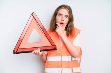 caucasian pretty woman with mouth and eyes wide open and hand on chin. car emergency concept