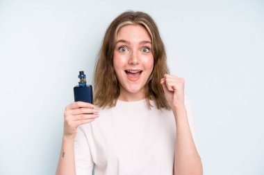 caucasian pretty woman feeling shocked,laughing and celebrating success. smoker with a vaper concept