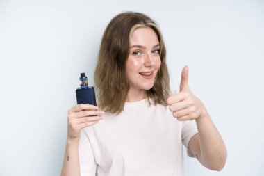 caucasian pretty woman feeling proud,smiling positively with thumbs up. smoker with a vaper concept
