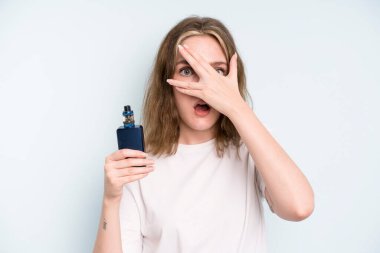 caucasian pretty woman looking shocked, scared or terrified, covering face with hand. smoker with a vaper concept