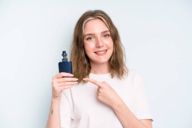 caucasian pretty woman smiling cheerfully, feeling happy and pointing to the side. smoker with a vaper concept