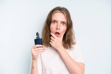caucasian pretty woman with mouth and eyes wide open and hand on chin. smoker with a vaper concept