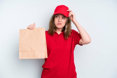 caucasian pretty woman feeling puzzled and confused, scratching head. delivery and take away concept