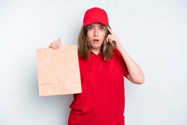 caucasian pretty woman looking surprised, realizing a new thought, idea or concept. delivery and take away concept