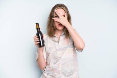 caucasian pretty woman looking shocked, scared or terrified, covering face with hand. beer concept