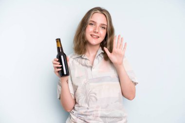 caucasian pretty woman smiling and looking friendly, showing number five. beer concept