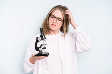 caucasian pretty woman smiling happily with a hand on hip and confident. science student with a microscope