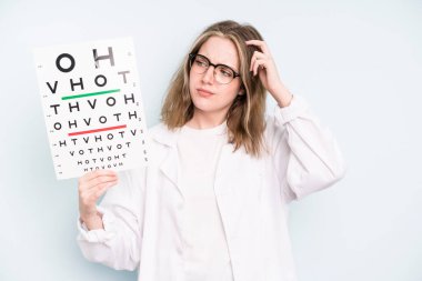 caucasian pretty woman smiling happily and daydreaming or doubting. optical vision test concept