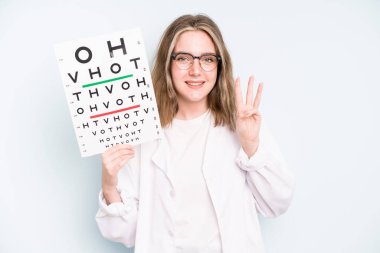 caucasian pretty woman smiling and looking friendly, showing number two. optical vision test concept