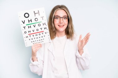 caucasian pretty woman looking surprised and shocked, with jaw dropped holding an object. optical vision test concept