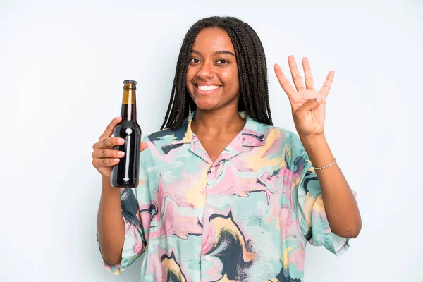 black pretty woman smiling and looking friendly, showing number four beer and holidays concept
