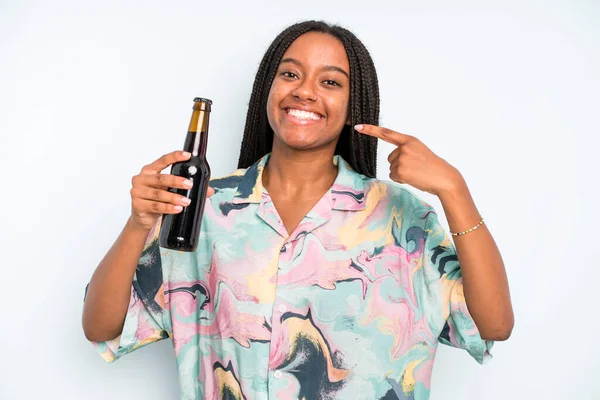 black pretty woman smiling confidently pointing to own broad smile beer and holidays concept