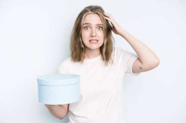 caucasian pretty woman looking serious showing open palm making stop gesture. gift box concept