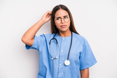 hispanic pretty woman smiling happily and daydreaming or doubting. medicine student concept
