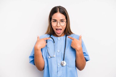 hispanic pretty woman feeling happy and pointing to self with an excited. medicine student concept