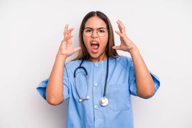 hispanic pretty woman screaming with hands up in the air. medicine student concept