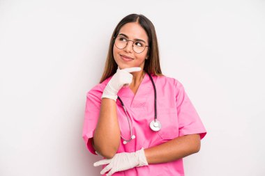 hispanic pretty woman smiling with a happy, confident expression with hand on chin. medicine student concept