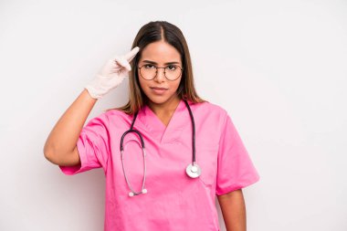hispanic pretty woman feeling confused and puzzled, showing you are insane. medicine student concept