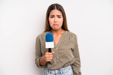 hispanic pretty woman feeling sad and whiney with an unhappy look and crying. presenter with a microphone concept