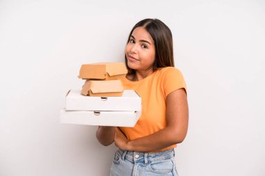 hispanic pretty woman shrugging, feeling confused and uncertain. fast food and take away concept
