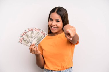 hispanic pretty woman pointing at camera choosing you. dollar banknotes savings concept