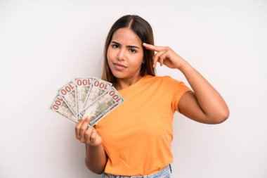 hispanic pretty woman feeling confused and puzzled, showing you are insane. dollar banknotes savings concept