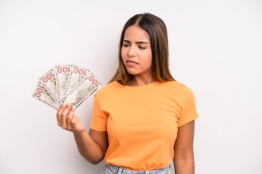 hispanic pretty woman feeling sad, upset or angry and looking to the side. dollar banknotes savings concept