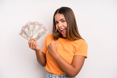 hispanic pretty woman feeling happy and facing a challenge or celebrating. dollar banknotes savings concept