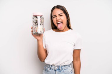 hispanic pretty woman with cheerful and rebellious attitude, joking and sticking tongue out. dollar banknotes savings concept