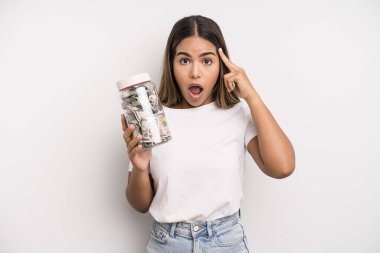 hispanic pretty woman looking surprised, realizing a new thought, idea or concept. dollar banknotes savings concept