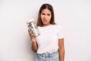 hispanic pretty woman feeling puzzled and confused. dollar banknotes savings concept