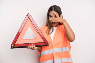 hispanic pretty woman looking shocked, scared or terrified, covering face with hand. car accident emergency concept