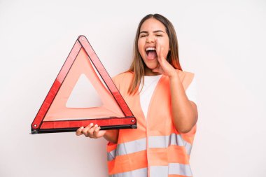hispanic pretty woman feeling happy,giving a big shout out with hands next to mouth. car accident emergency concept