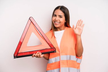 hispanic pretty woman smiling happily, waving hand, welcoming and greeting you. car accident emergency concept