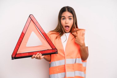 hispanic pretty woman looking shocked and surprised with mouth wide open, pointing to self. car accident emergency concept