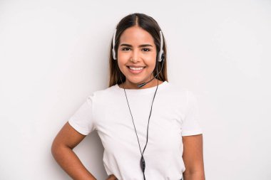 hispanic pretty woman smiling happily with a hand on hip and confident. telemarketer concept