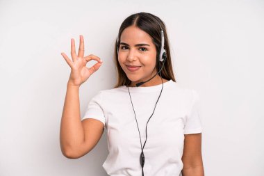 hispanic pretty woman feeling happy, showing approval with okay gesture. telemarketer concept