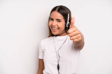 hispanic pretty woman feeling proud,smiling positively with thumbs up. telemarketer concept