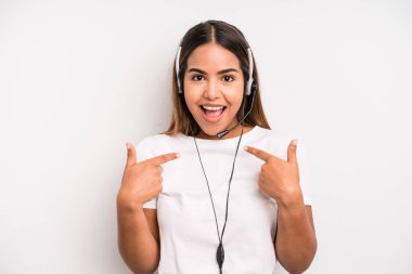 hispanic pretty woman feeling happy and pointing to self with an excited. telemarketer concept