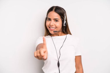 hispanic pretty woman smiling proudly and confidently making number one. telemarketer concept