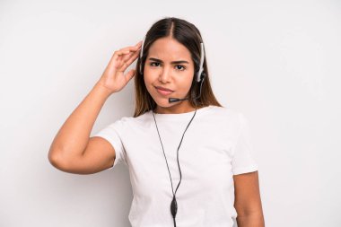 hispanic pretty woman feeling confused and puzzled, showing you are insane. telemarketer concept